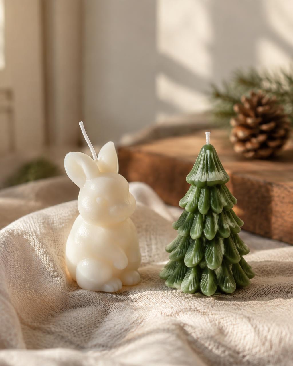 Handmade rabbit and fir tree candles on linen